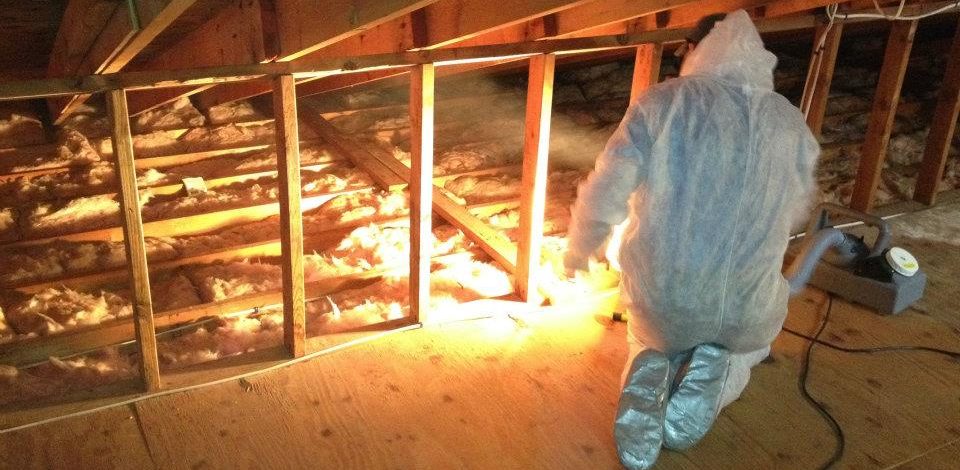 Worker in attic adding insulation